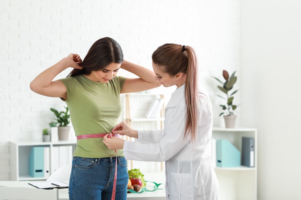 Doctor consulting patient about CoolSculpting procedure.