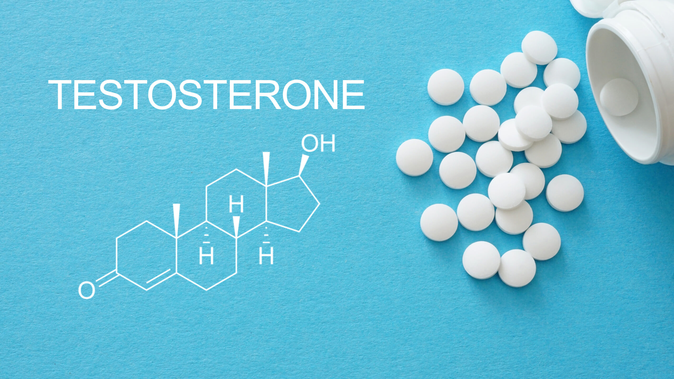White round tablets spill from an open container onto a blue surface beside a diagram labeled “TESTOSTERONE.”